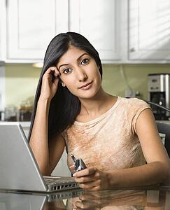 Young Woman With Laptop and Holding Cellphone