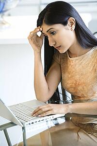 Concerned Young Woman Using Laptop