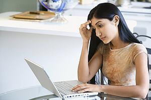 Concerned Young Woman Using Laptop