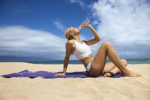 Young Woman Drinking on Beach