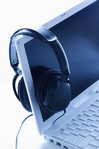 Headphones Hanging on Screen of Laptop