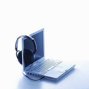 Headphones Hanging on Screen of Laptop