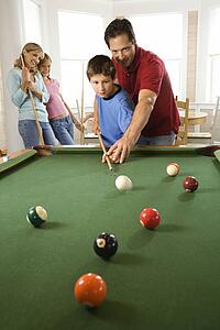 Family Playing Pool in Rec Room