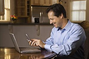Man with Cell Phone and Laptop