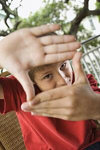 Boy Looking Through Hands