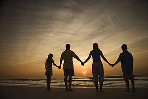Family Holding Hands on Beach 