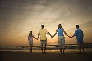 Family holding hands on beach