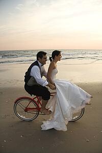 Couple Riding Bike on Beach