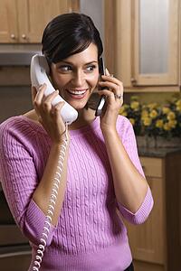 Woman talking on two telephones