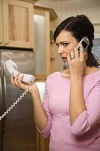Serious woman on two telephones