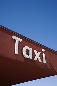 Taxi Sign On a Brown Wall