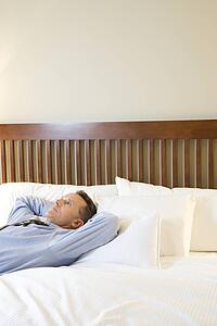 Businessman Relaxing on Bed
