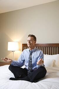 Businessman Meditating on Bed