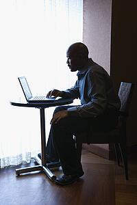 Businessman with Laptop at Cafe Table