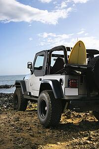 SUV and Surfboard at the Beach