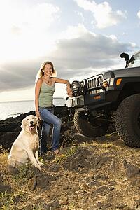 Woman and Dog by SUV at the Beach