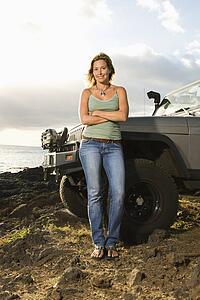 Woman by SUV at the Beach
