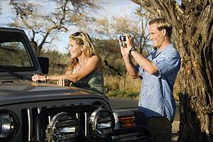 Tourist Couple Standing By Car