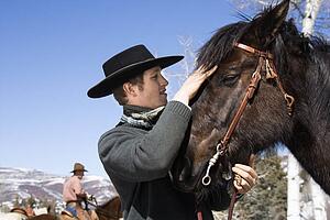 Attractive Young Man Petting Horse