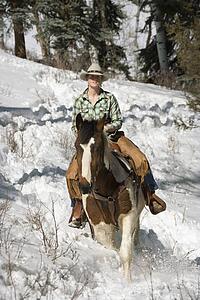 Attractive Young Woman Riding a Horse in the Snow
