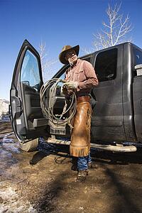 Man Wearing Cowboy Hat With Lariat and Truck