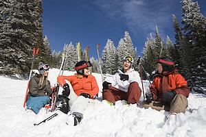 Skiers Sitting in Snow Talking