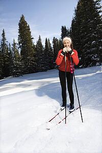 Female Snow Skier Leaning on Poles and Smiling