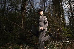 Young Businessman Running In Woods