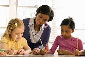 Teacher Helping Students With Schoolwork 