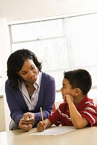 Teacher Helping Boy With Schoolwork 