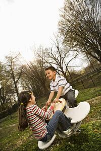 Young Girl and Boy Playing on Seesaw