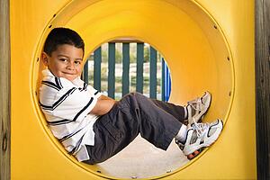 Young Boy Lying in Crawl Tube