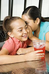 Young Girl Whispering to Another