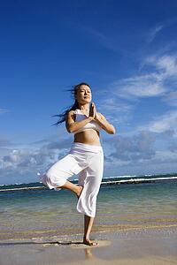 Woman Doing Yoga on Beach