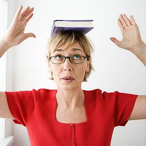 Woman balancing book on her head.