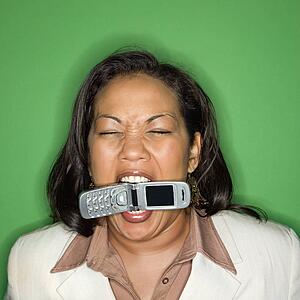 Businesswoman biting cellphone