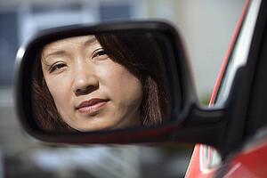 Serious woman in car mirror