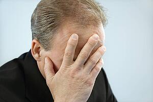 Businessman covering face