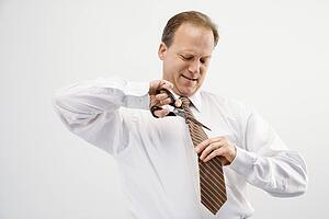 Businessman cutting necktie
