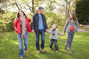 Young Family Outdoors Walking Through Park