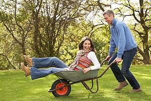 Couple With Man Giving Woman Ride In Wheelbarrow