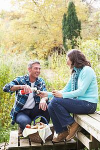 Couple Enjoying Picnic Outdoors In Autumn Woodland