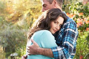 Close Up Of Romantic Couple Embracing By Autumn Woodland