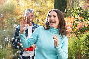 Couple Outdoors In Autumn Landscape With Bubble Machine