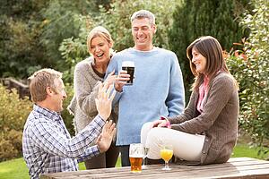 Group Of Friends Outdoors Enjoying Drink In Pub Garden