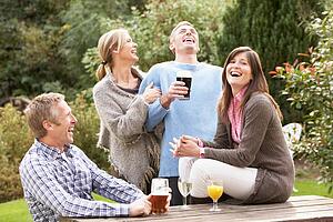 Group Of Friends Outdoors Enjoying Drink In Pub Garden