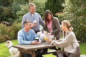 Group Of Friends Outdoors Enjoying Drink In Pub Garden