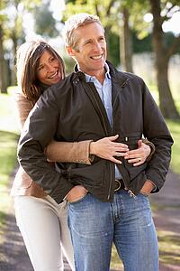 Portrait Of Romantic Couple Enjoying Outdoor Walk Through Autumn Park