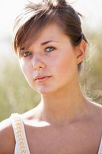 Portrait Of Beautiful Young Woman Relaxing On Beach