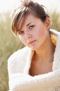 Portrait Of Beautiful Young Woman Relaxing On Beach